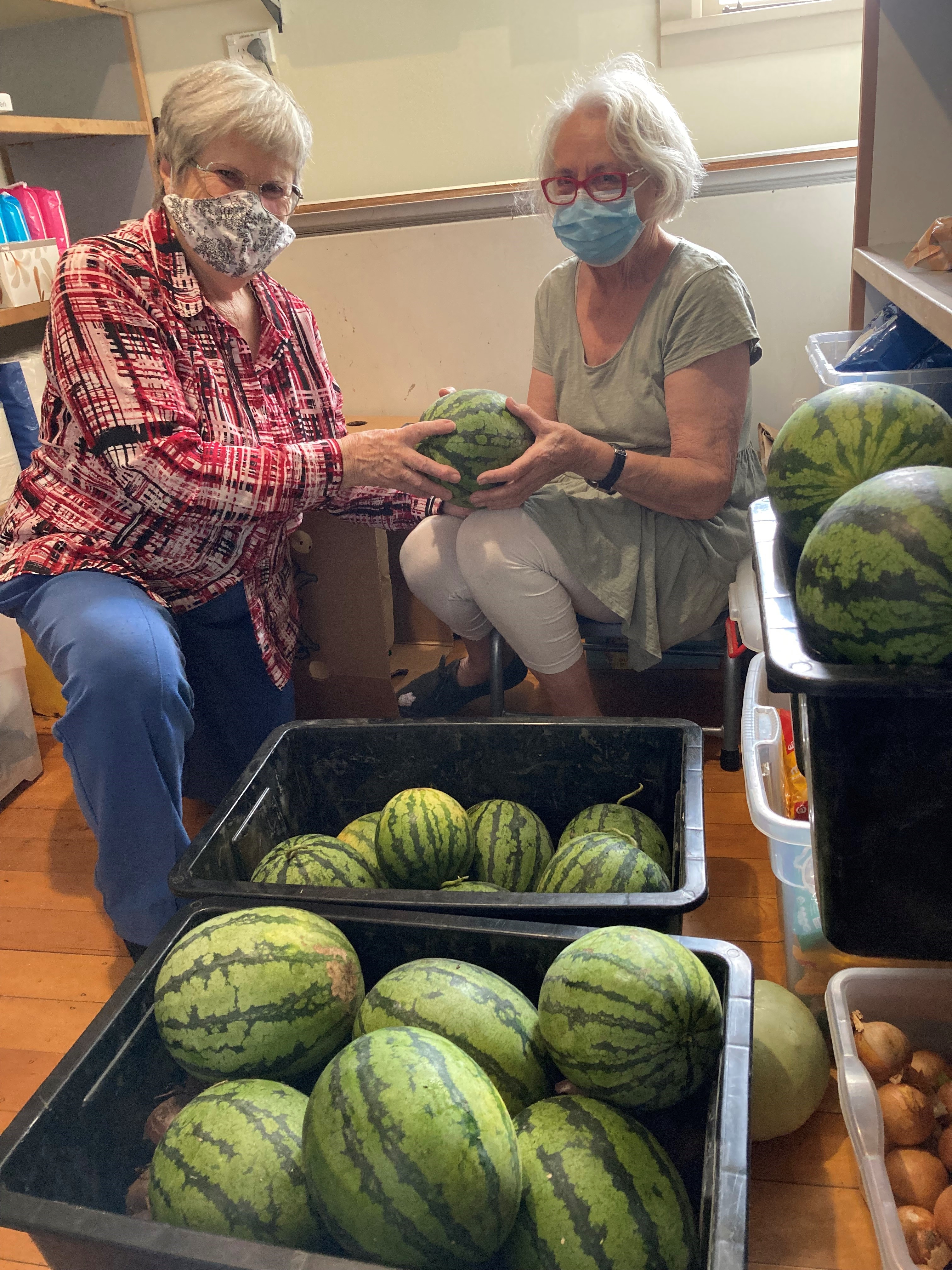 Volunteers for the Dargaville Combined Churches Food Bank are pictured with two crates of watermelons ready for distribution